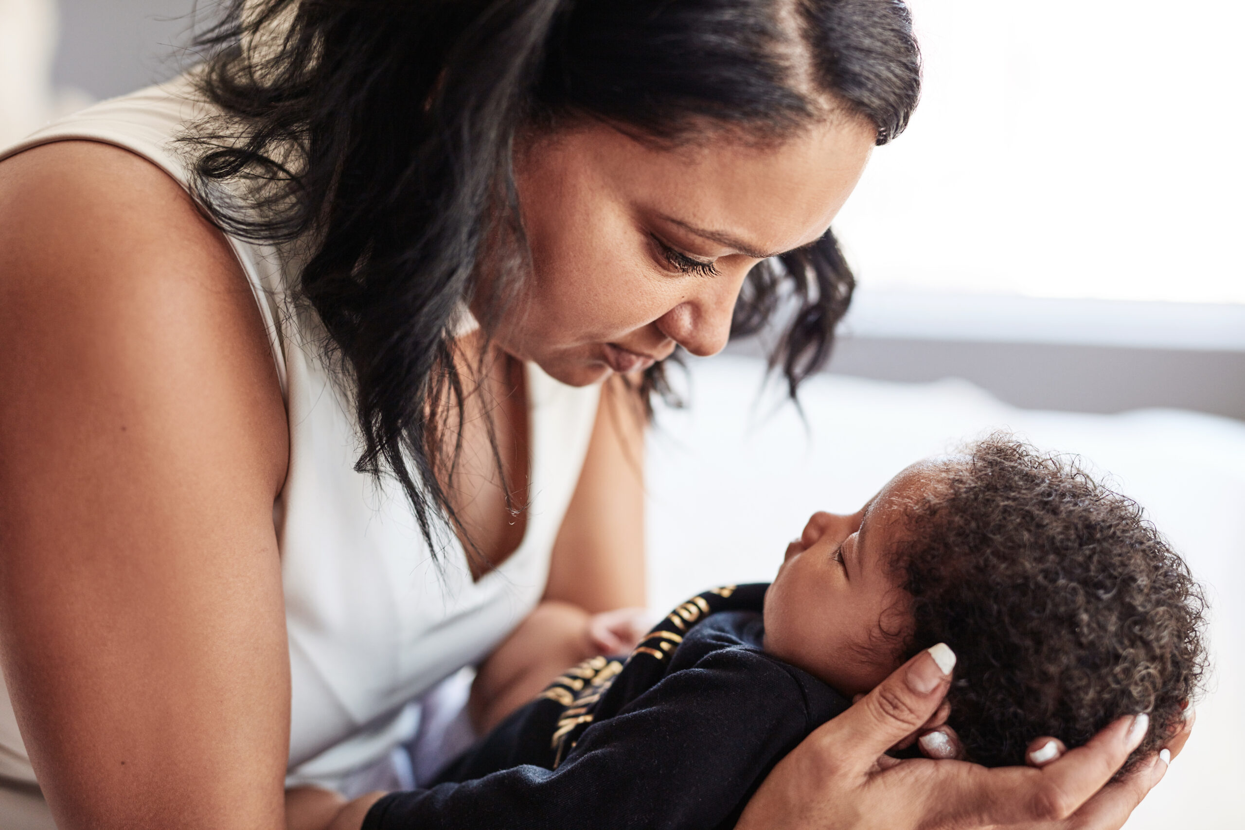 Cropped shot of an affectionate young single mother holding her sleeping baby at home